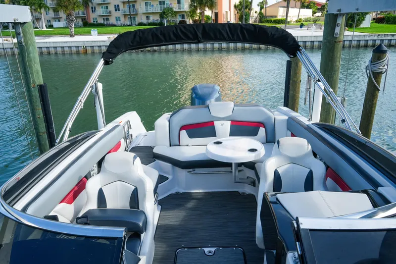 Slide: The Image of 2018 Four Winns HD240 OB boat interior with stylish seating and table, docked by the water. - 32