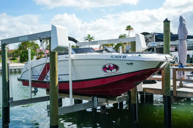 Slide: The Image of 2018 Four Winns HD240 OB boat on lift, featuring custom "The Batboat" decal. - 52