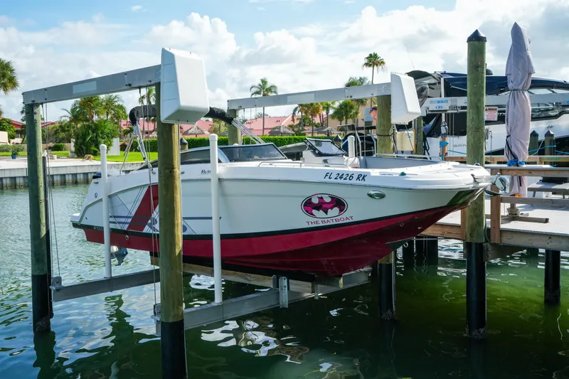 Slide: The Image of 2018 Four Winns HD240 OB boat on lift, docked in sunny marina setting. - 49