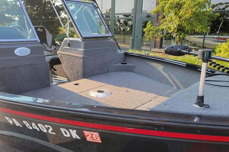 Slide: The Image of 2014 G3 Angler V164 F boat with spacious deck and windshield, parked outdoors. - 5