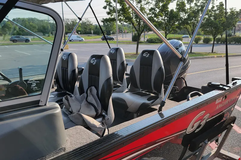 Slide: The Image of 2014 G3 Angler V164 F boat with seating and motor in a parking lot. - 9