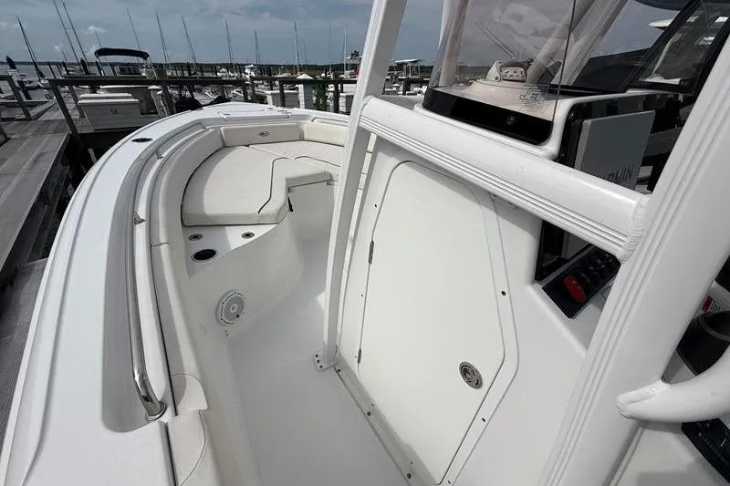 Slide: The Image of 2022 Sea Hunt Ultra 234 boat interior with seating and console, docked at marina. - 21