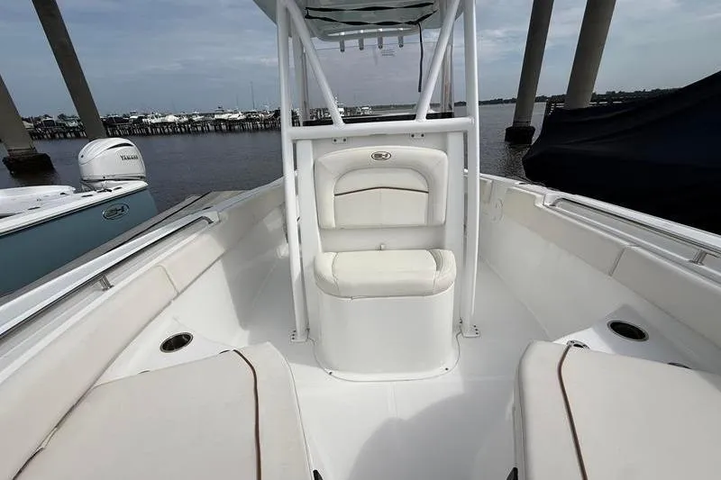 Slide: The Image of 2022 Sea Hunt Ultra 234 boat interior with seating, docked by the water. - 27