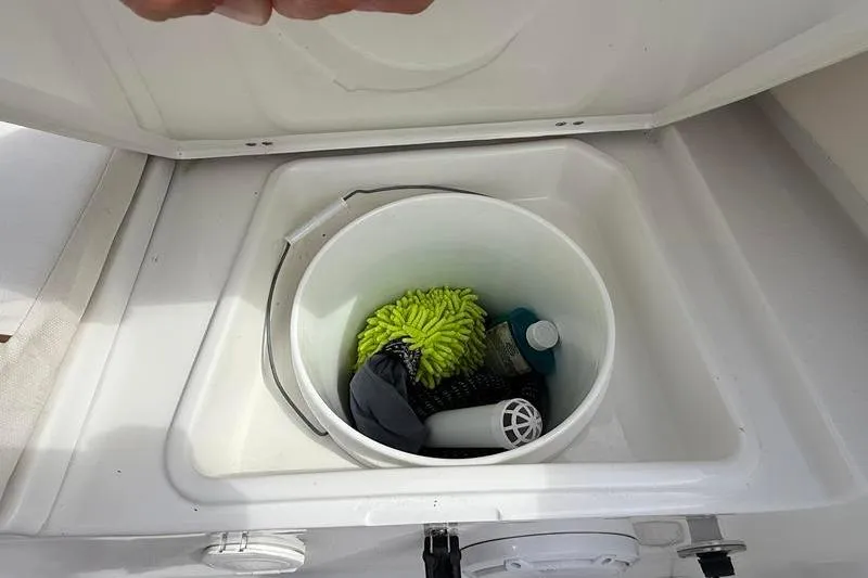 Slide: The Image of Storage compartment on a 2022 Sea Hunt Ultra 234 boat with cleaning supplies. - 6