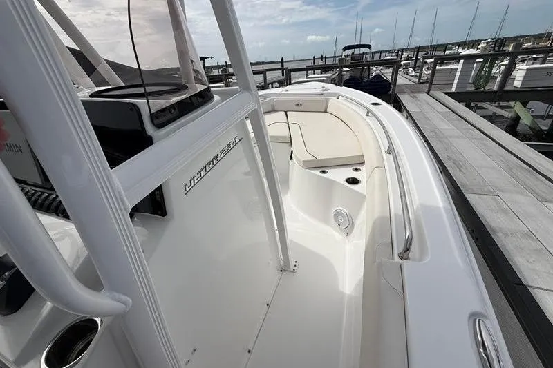 Slide: The Image of 2022 Sea Hunt Ultra 234 boat interior at marina, showcasing sleek design and seating. - 20