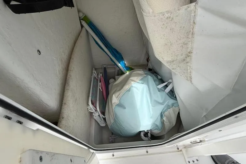 Slide: The Image of Storage compartment in a 2022 Sea Hunt Ultra 234 boat with bags and equipment. - 23