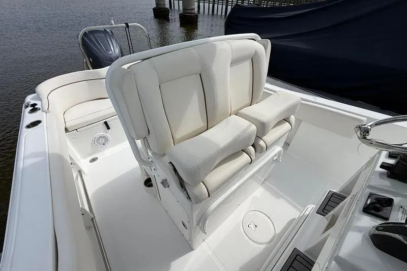 Slide: The Image of 2022 Sea Hunt Ultra 234 boat interior with white cushioned seating and helm. - 12