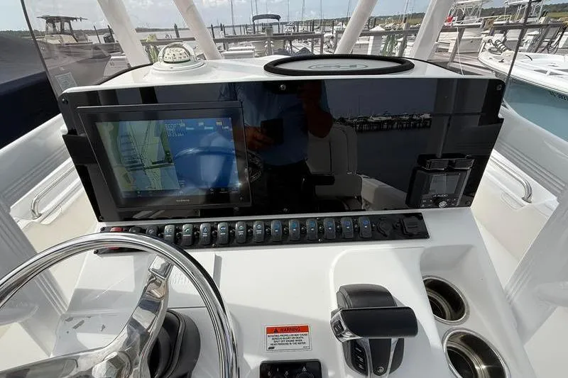 Slide: The Image of 2022 Sea Hunt Ultra 234 boat dashboard with navigation screen and controls. - 13