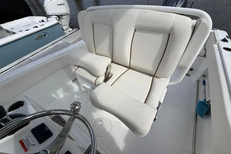 Slide: The Image of 2022 Sea Hunt Ultra 234 boat interior with white cushioned seating and steering wheel. - 11