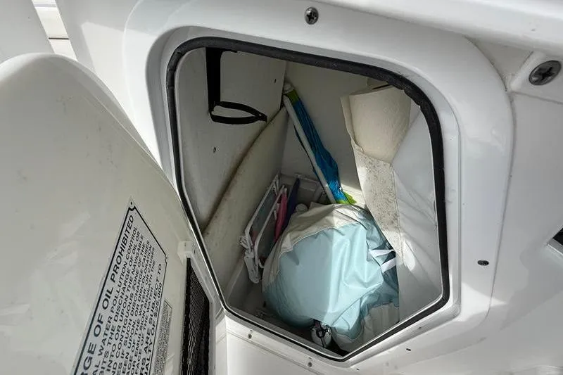 Slide: The Image of Storage compartment of a 2022 Sea Hunt Ultra 234 boat, containing various items. - 28