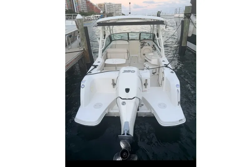 Slide: The Image of 2020 Boston Whaler 230 Vantage docked, showcasing spacious deck and powerful outboard motor. - 16