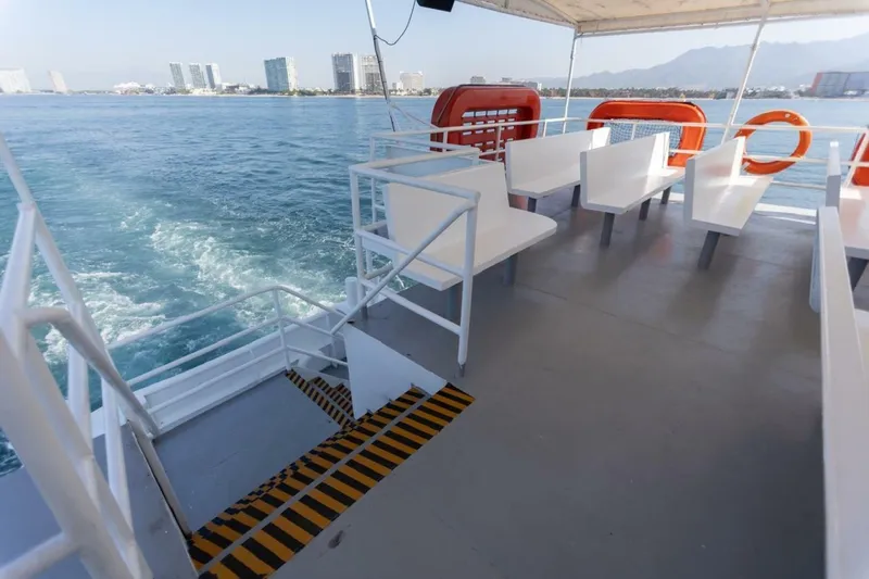 Slide: The Image of A passenger ferry with white benches and lifebuoys on deck, cruising on calm waters. - 2