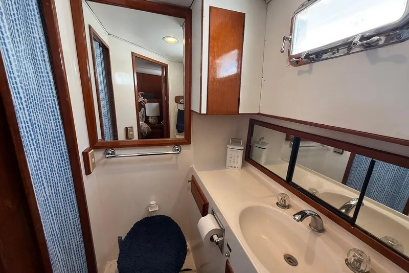 Slide: The Image of Bathroom interior of 1985 DeFever 40 Offshore Cruiser with sink, mirror, and wooden accents. - 29