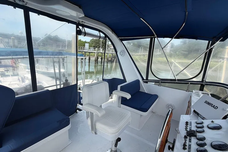 Slide: The Image of 1985 DeFever 40 Offshore Cruiser helm with blue seating and navigation equipment. - 17