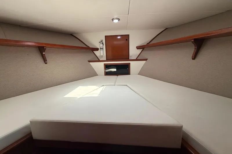 Slide: The Image of Interior cabin of 1985 DeFever 40 Offshore Cruiser with cushioned berth and wooden shelves. - 41