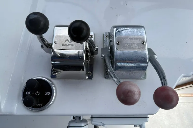 Slide: The Image of Boat throttle controls on a 1985 DeFever 40 Offshore Cruiser, featuring Dometic and Morse levers. - 19
