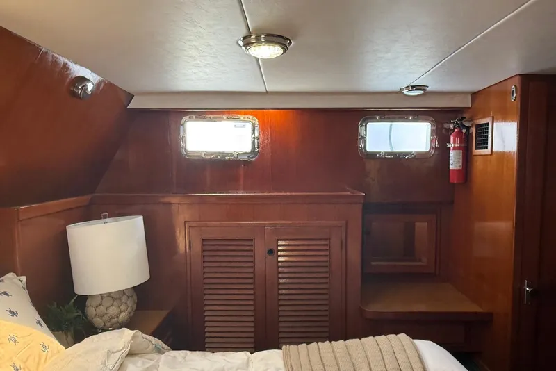 Slide: The Image of Cozy cabin interior of 1985 DeFever 40 Offshore Cruiser with wood paneling and porthole windows. - 25
