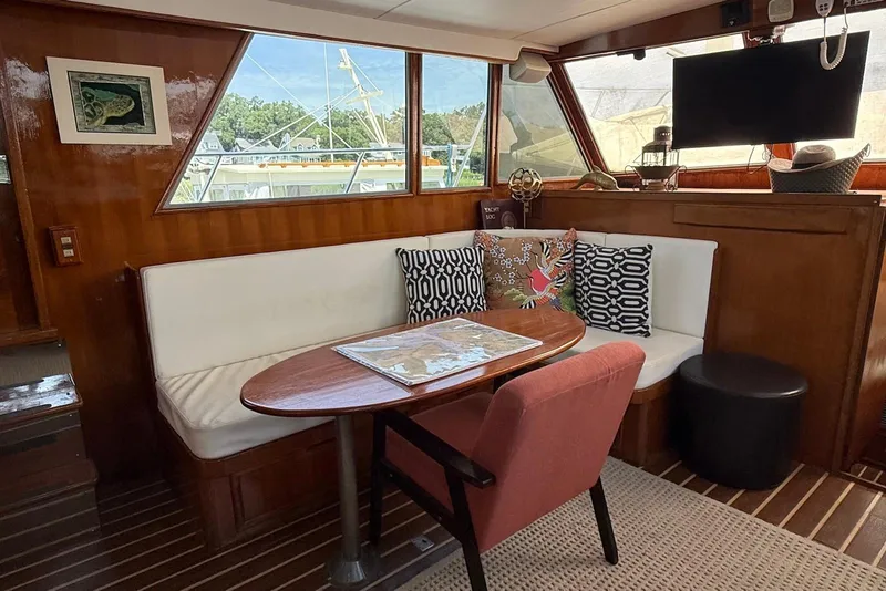 Slide: The Image of 1985 DeFever 40 Offshore Cruiser interior with cozy seating, table, and nautical decor. - 34