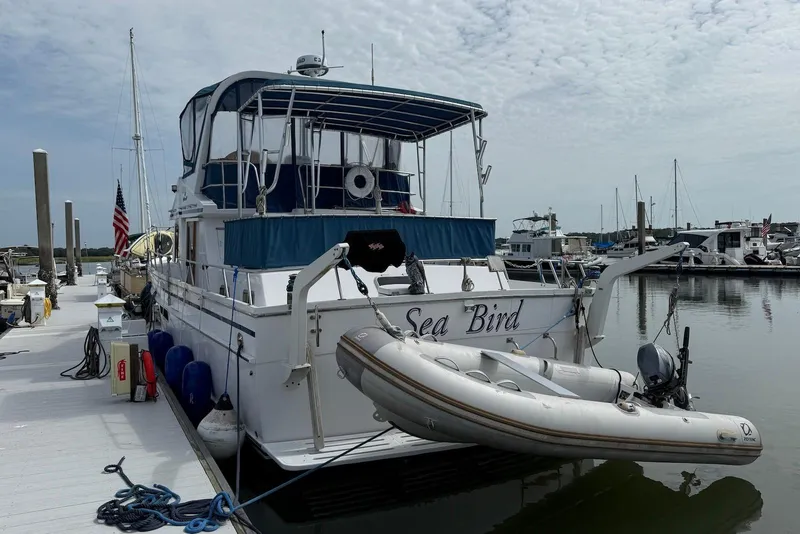 Slide: The Image of 1985 DeFever 40 Offshore Cruiser docked, featuring "Sea Bird" name and inflatable dinghy. - 9