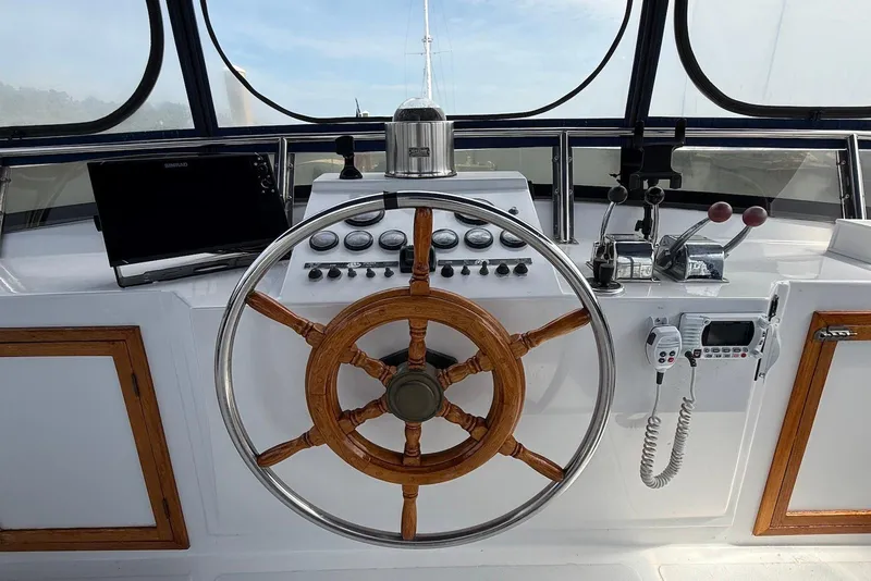 Slide: The Image of Helm of 1985 DeFever 40 Offshore Cruiser with wooden wheel and navigation controls. - 12