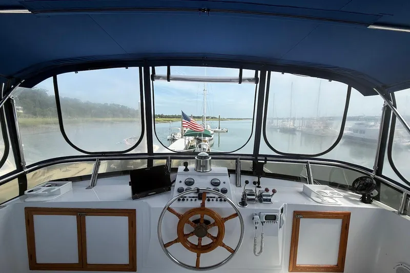 Slide: The Image of Helm of 1985 DeFever 40 Offshore Cruiser with marina view and American flag. - 14