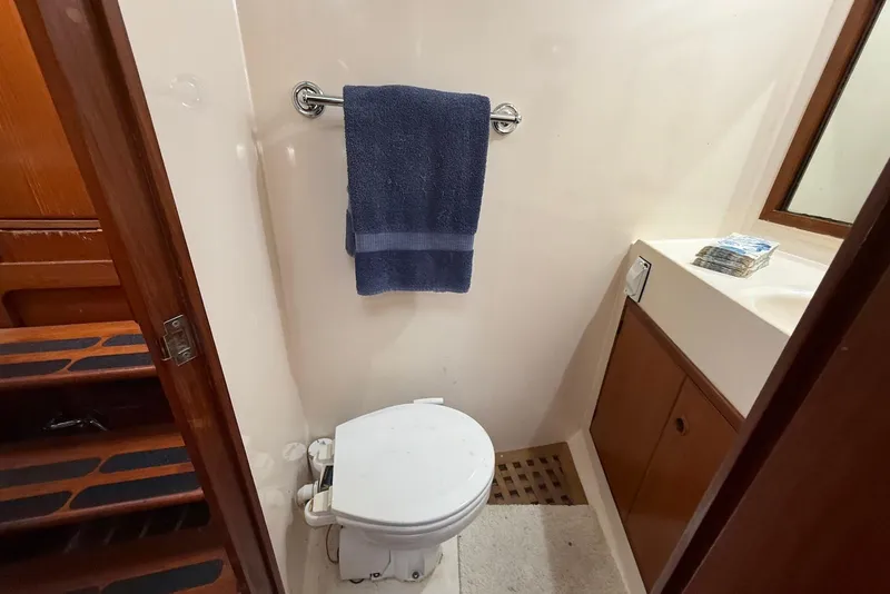 Slide: The Image of 1985 DeFever 40 Offshore Cruiser bathroom with toilet, towel, and sink area. - 44
