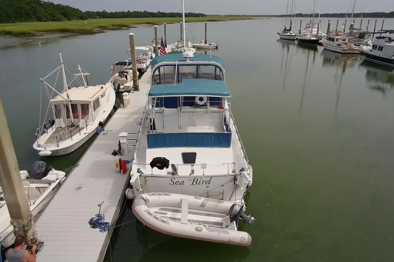 Slide: The Image of 1985 DeFever 40 Offshore Cruiser "Sea Bird" docked at a marina with surrounding boats. - 3
