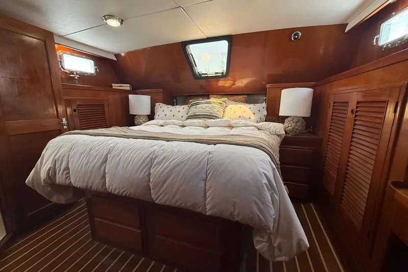 Slide: The Image of Cozy bedroom in 1985 DeFever 40 Offshore Cruiser with wood paneling and plush bedding. - 23