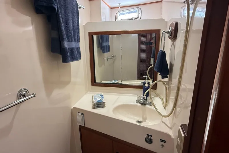 Slide: The Image of Bathroom interior of 1985 DeFever 40 Offshore Cruiser with sink, mirror, and towels. - 43