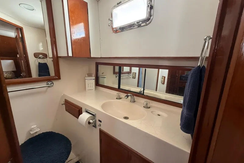 Slide: The Image of Bathroom interior of 1985 DeFever 40 Offshore Cruiser with sink, mirror, and wooden cabinetry. - 27