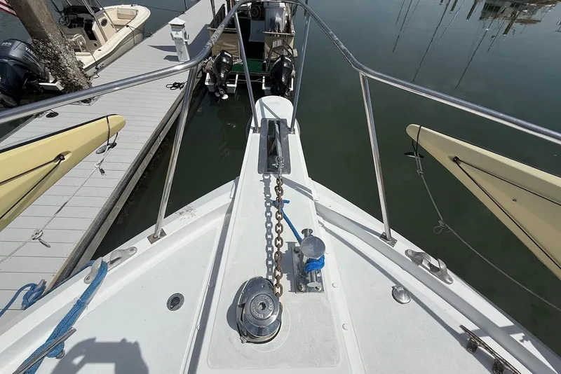 Slide: The Image of Bow view of 1985 DeFever 40 Offshore Cruiser at dock, showing anchor chain and deck details. - 21