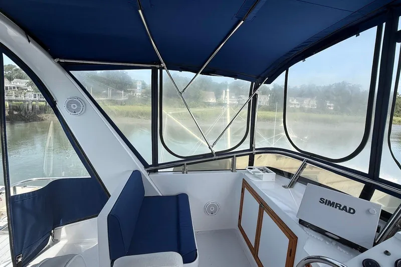 Slide: The Image of 1985 DeFever 40 Offshore Cruiser helm with blue seating and Simrad navigation system. - 16