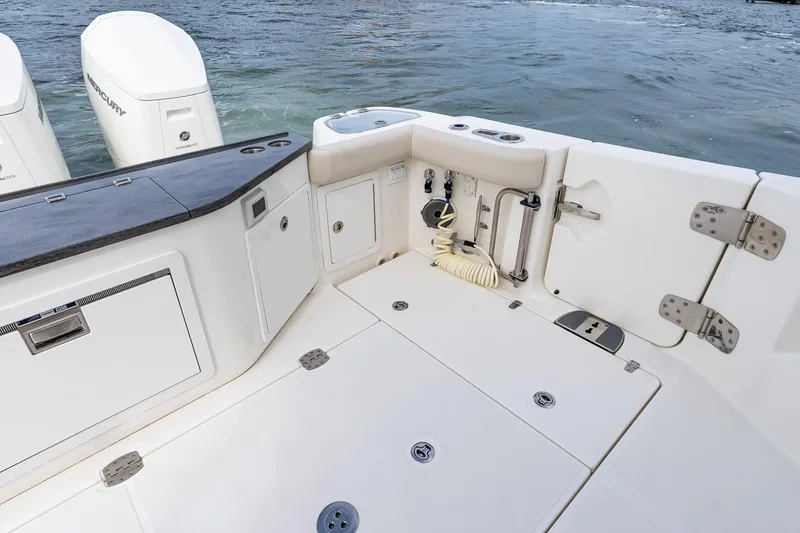 Slide: The Image of 2024 Boston Whaler 405 Conquest boat deck with storage and dual Mercury engines. - 16