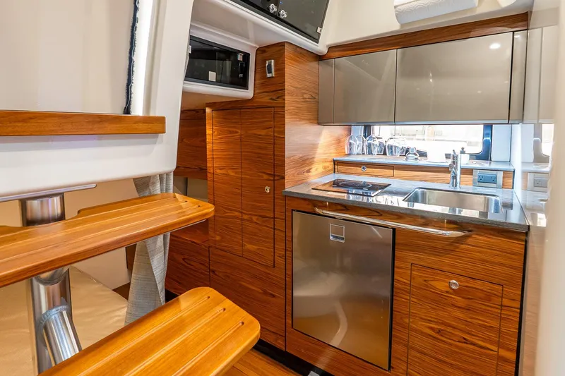 Slide: The Image of 2024 Boston Whaler 405 Conquest interior kitchen with wood finish and modern appliances. - 53