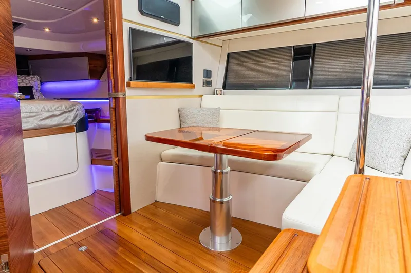 Slide: The Image of 2024 Boston Whaler 405 Conquest interior with elegant seating and wooden table. - 50