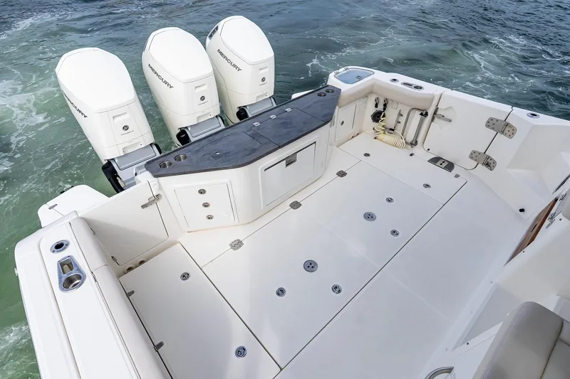 Slide: The Image of 2024 Boston Whaler 405 Conquest boat deck with triple Mercury engines. - 14
