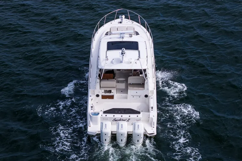 Slide: The Image of 2024 Boston Whaler 405 Conquest cruising on open water, rear view. - 6