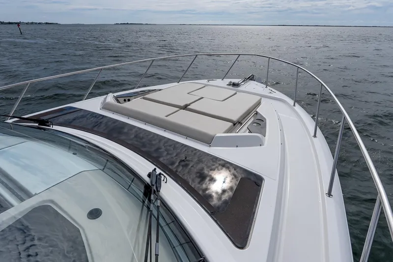 Slide: The Image of 2024 Boston Whaler 405 Conquest boat deck with sun pad, cruising on open water. - 63