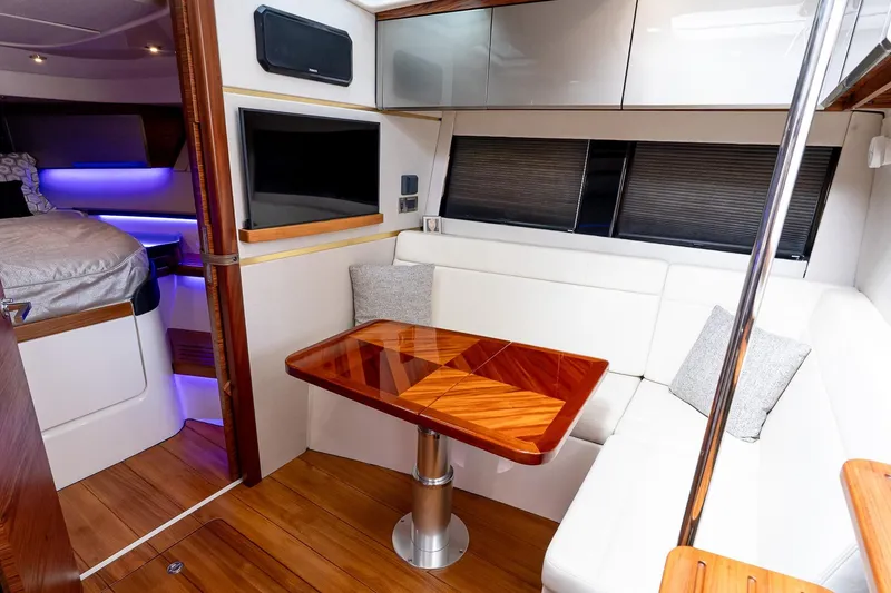 Slide: The Image of 2024 Boston Whaler 405 Conquest interior with elegant seating and wooden table. - 51