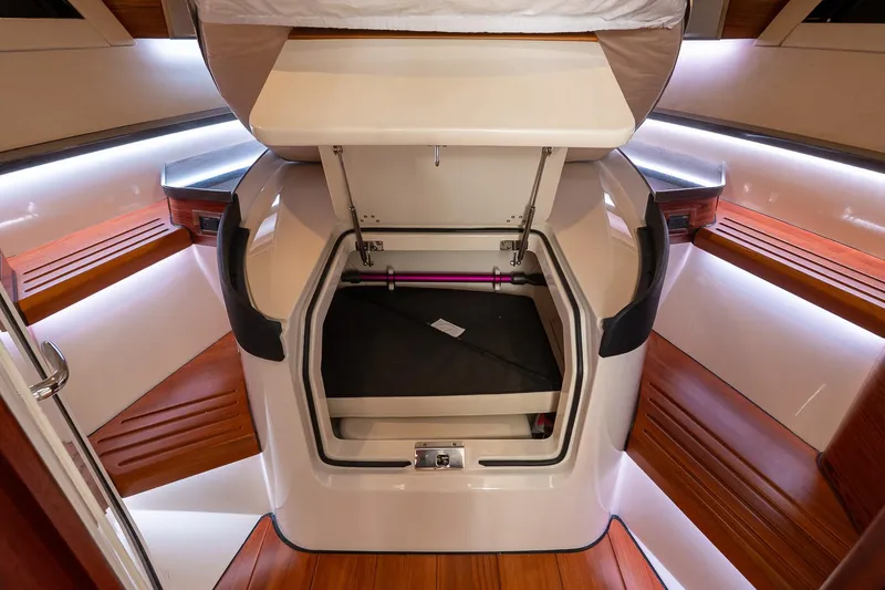 Slide: The Image of 2024 Boston Whaler 405 Conquest cabin interior with storage compartment open. - 48