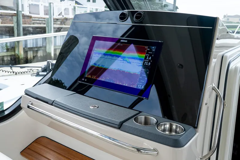 Slide: The Image of 2024 Boston Whaler 405 Conquest dashboard with Simrad display and cup holders. - 46