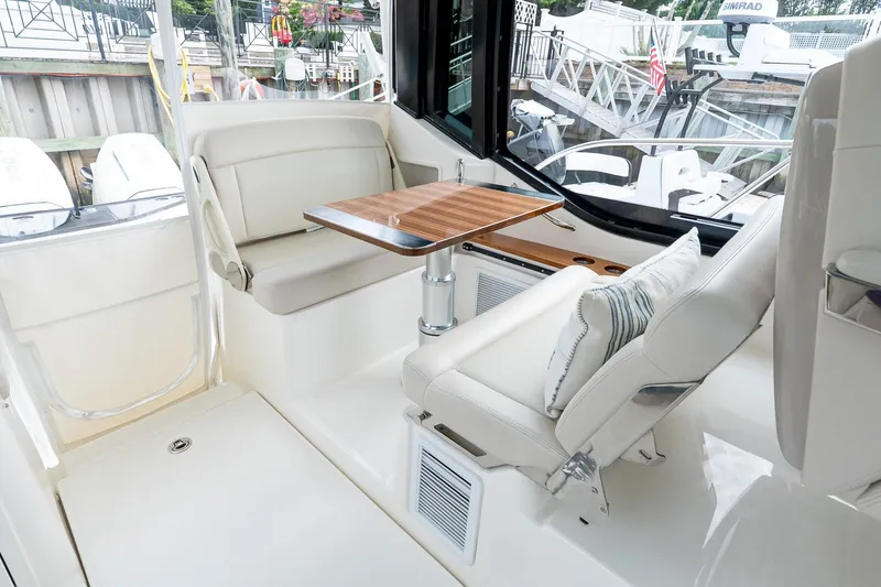 Slide: The Image of 2024 Boston Whaler 405 Conquest interior with seating and wooden table. - 36