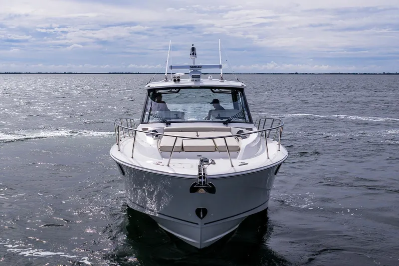 Slide: The Image of 2024 Boston Whaler 405 Conquest cruising on open water under a cloudy sky. - 5