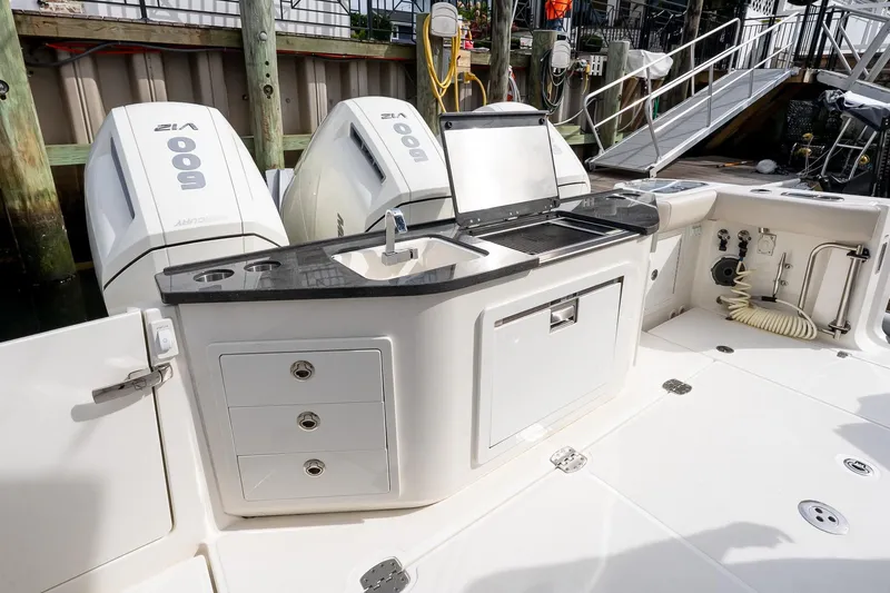 Slide: The Image of 2024 Boston Whaler 405 Conquest boat with dual engines and outdoor kitchen setup. - 17
