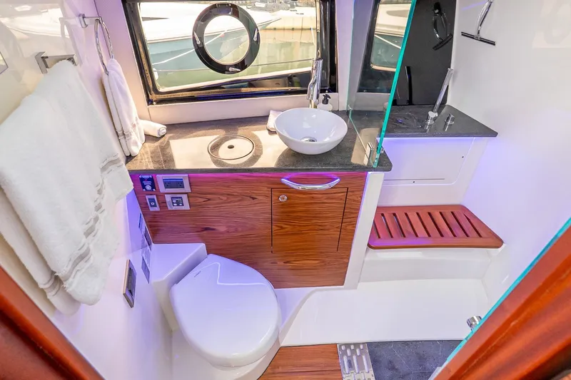 Slide: The Image of Luxurious bathroom interior of 2024 Boston Whaler 405 Conquest yacht, featuring modern fixtures and wood accents. - 59