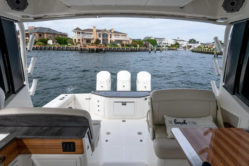 Slide: The Image of 2024 Boston Whaler 405 Conquest boat interior with waterfront view and luxurious seating. - 12