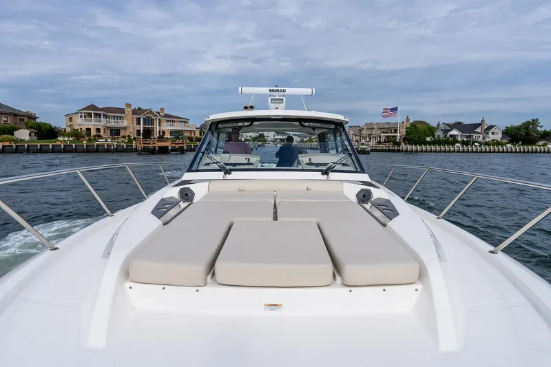 Slide: The Image of 2024 Boston Whaler 405 Conquest cruising near waterfront homes, showcasing luxury and comfort. - 60