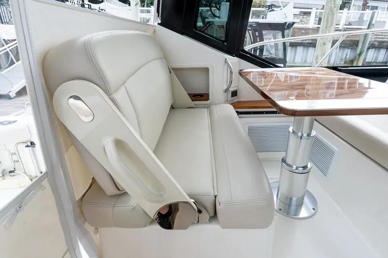 Slide: The Image of 2024 Boston Whaler 405 Conquest interior with beige seating and wooden table. - 35