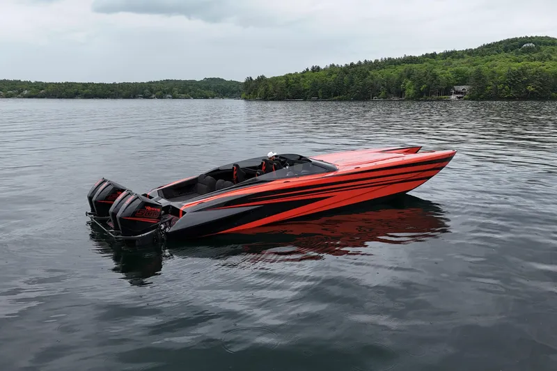 Slide: The Image of 2027 Nor-Tech 4000 Roadster speedboat with striking orange and black design on a serene lake. - 2