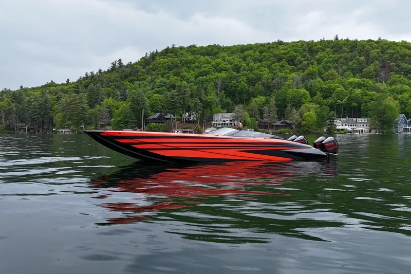 Slide: The Image of 2027 Nor-Tech 4000 Roadster speedboat on a serene lake with lush green hills. - 10